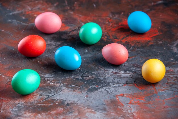 Uova colorate disposte su sfondo scuro con colori misti in difficoltà con spazio libero