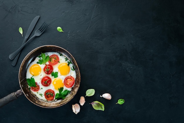 Uova con pomodori e verdure in una padella