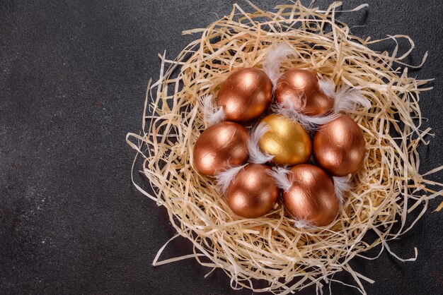 Uova d'oro di Pasqua nel nido, preparazione per le vacanze. Uova d'oro nel nido