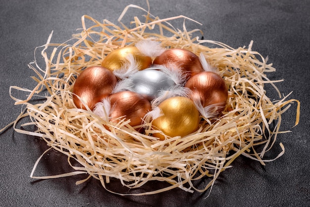 Uova d'oro di Pasqua nel nido, preparazione per le vacanze. Uova d'oro nel nido