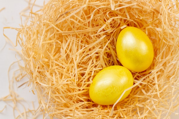 Uova d'oro per la Pasqua in un nido di chip di albero, vista dall'alto