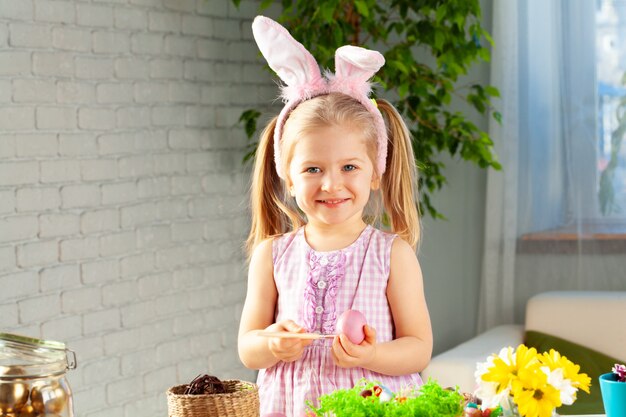 Uova della pittura della bambina per Pasqua a casa