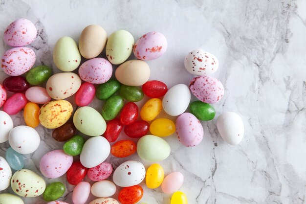 Uova di cioccolato della caramella di Pasqua e dolci di gelatina su fondo di marmo grigio