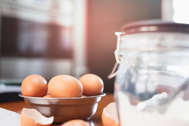 Uova di gallina in una ciotola con ingredienti da forno sul tavolo