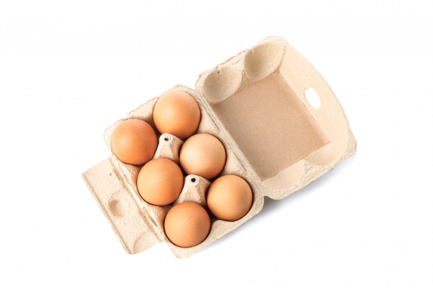 Uova di gallina marrone in scatola di cartone isolato su bianco
