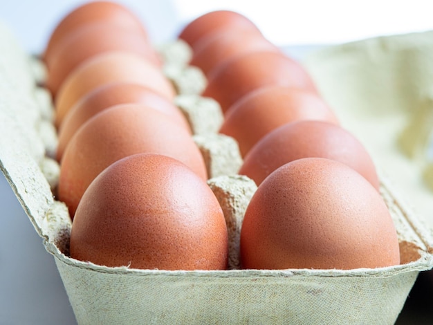 Uova di gallina marroni nel pacchetto di cartone riprese da un angolo basso