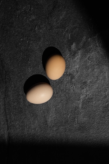 Uova di gallina organiche su fondo di legno scuro con lo spazio della copia