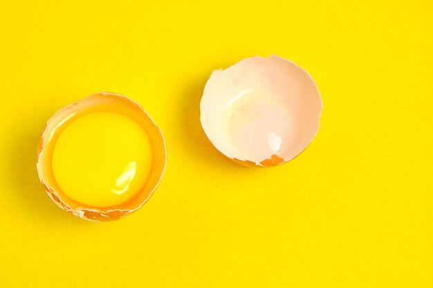 Uova di gallina su uno sfondo giallo rotto con tuorlo.
