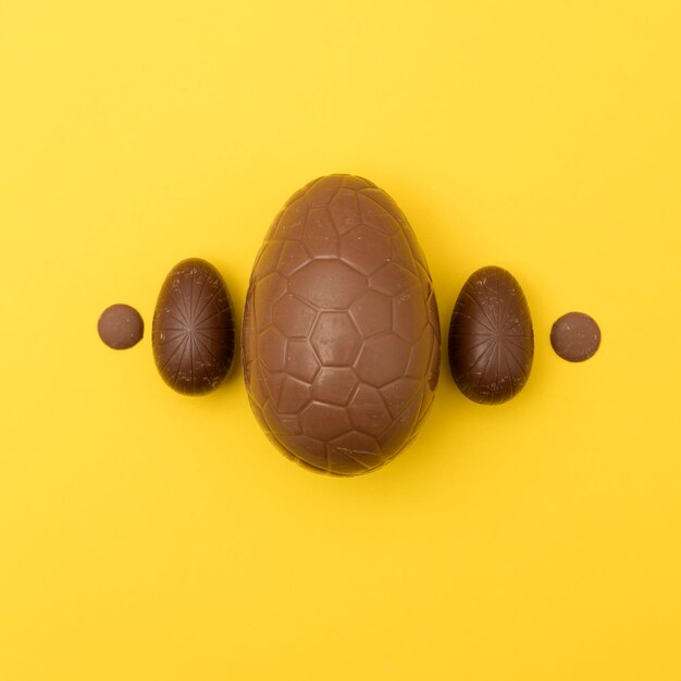 Uova di Pasqua al cioccolato su sfondo giallo brillante Concetto di vacanza di Pasqua