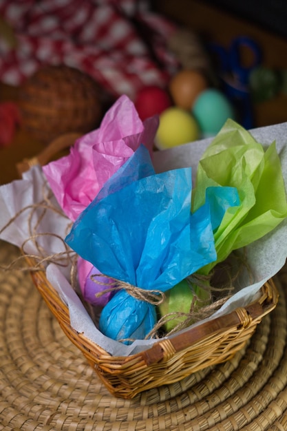 Uova di Pasqua avvolte in carta colorata all'interno di un cesto di vimini