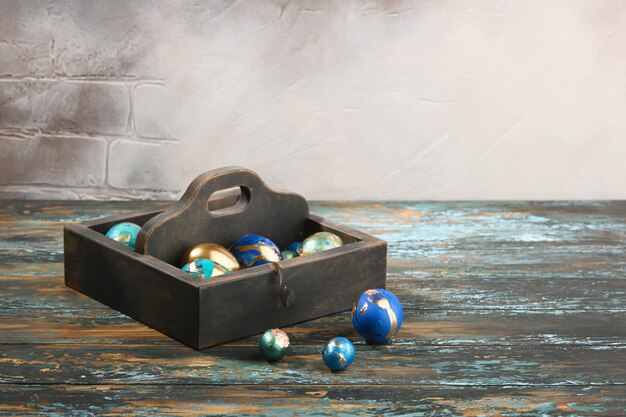 Uova di Pasqua colorate dipinte in scatola di legno scura