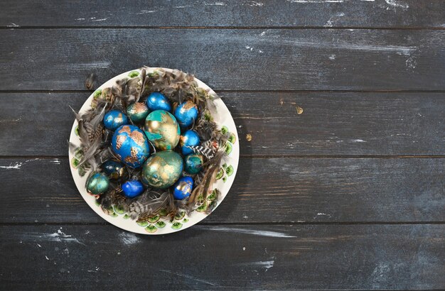 Uova di Pasqua colorate dipinte su pelle animale in piastra su sfondo di legno scuro Stile Boho