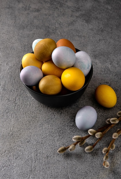 Uova di Pasqua colorate naturali. Composizione di Pasqua su sfondo grigio cemento.