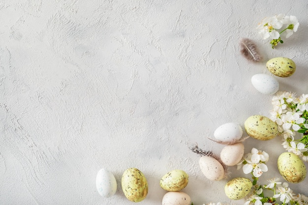 Uova di Pasqua colorate pastello e rami fioriti primaverili su bianco