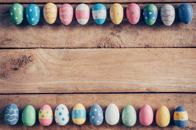 Uova di Pasqua colorate su sfondo di legno con spazio. Annata tonica.