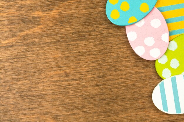 Uova di Pasqua colorate su uno sfondo di legno, design del bordo. Foto di spazio piatto e copia