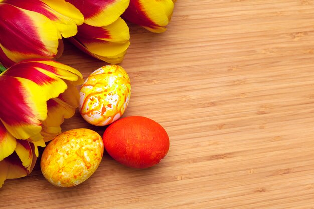 Uova di Pasqua Con i tulipani sul bordo di legno, concetto di festa di pasqua. Copyspace per il testo