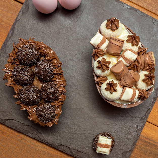 Uova di Pasqua di cioccolato in cima alla pietra nera con fondo in legno