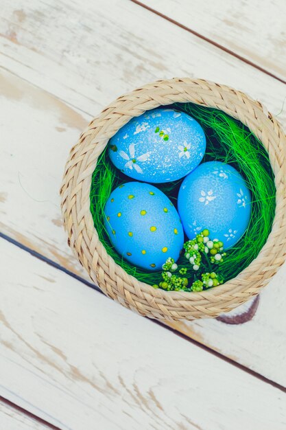 Uova di Pasqua dipinte nei colori pastelli su di legno bianco.