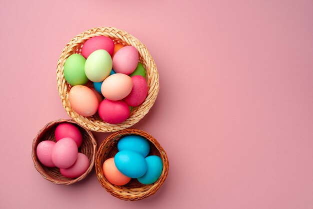 Uova di Pasqua dipinte nel nido decorativo sulla fine rosa su