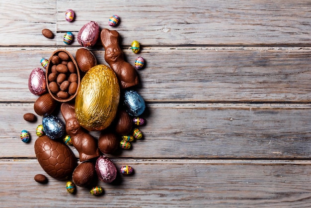 Uova di Pasqua e coniglietti di cioccolato su un fondo di legno rustico