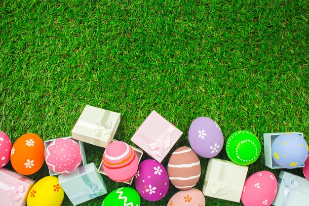 Uova di Pasqua E contenitore di regalo sull'erba verde