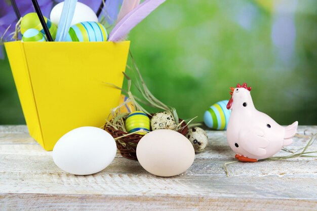 Uova di Pasqua e decorazioni tradizionali su un tavolo di legno sullo sfondo della natura primaverile