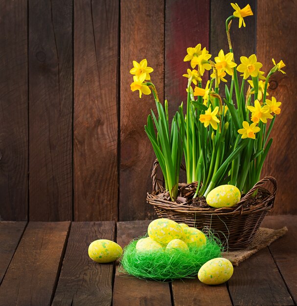 Uova di Pasqua e fiori su una tavola di legno scura