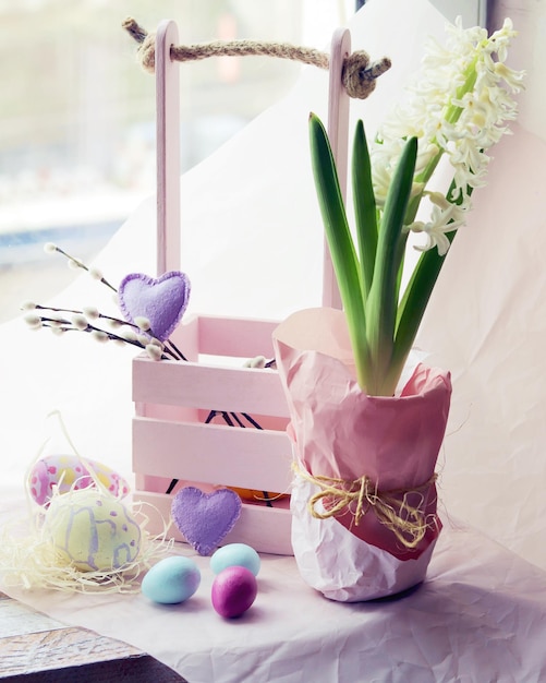 Uova di Pasqua Giacinto in fiore in un vaso di fiori decorazioni giocattolo su uno sfondo chiaro