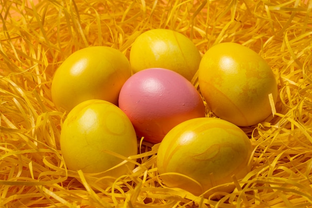 Uova di Pasqua gialle su sfondo di paglia