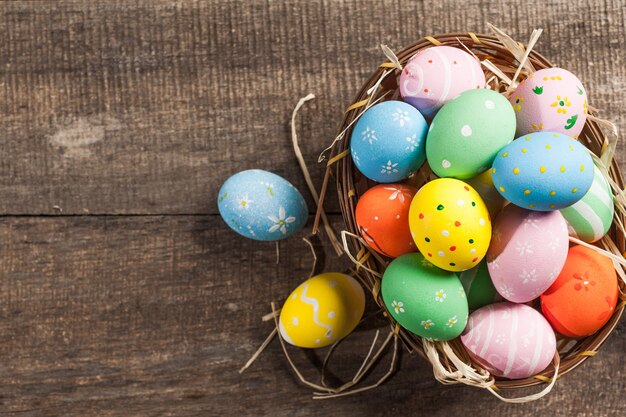 Uova di Pasqua In nido sulla tavola di legno di colore