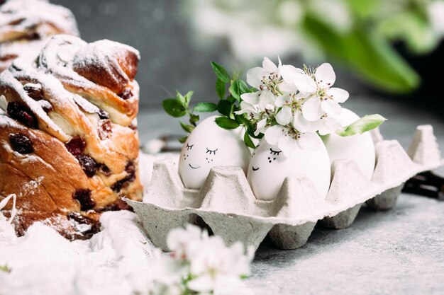 Uova di Pasqua in un cartone con fiori sul tavolo