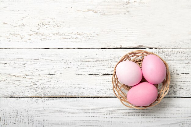 Uova di Pasqua In un cestino su un bianco di legno