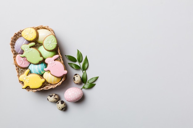 Uova di Pasqua multicolori nel cesto intrecciato su sfondo colorato Concetto di vacanza delle uova di Pasqua di colore pastello con spazio per la copia