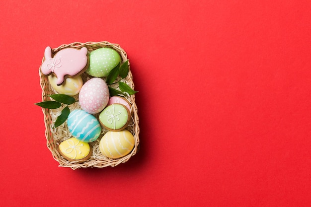 Uova di Pasqua multicolori nel cesto intrecciato su sfondo colorato Concetto di vacanza delle uova di Pasqua di colore pastello con spazio per la copia