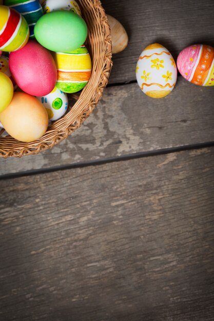 Uova di Pasqua nel cestino su assi di legno