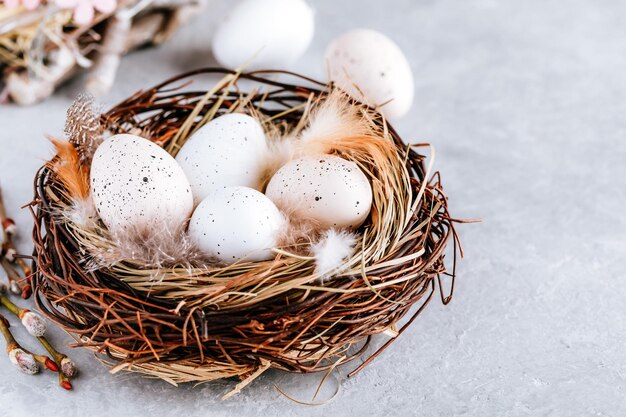 Uova di Pasqua nel nido su sfondo grigio pietra copia spazio Buona Pasqua