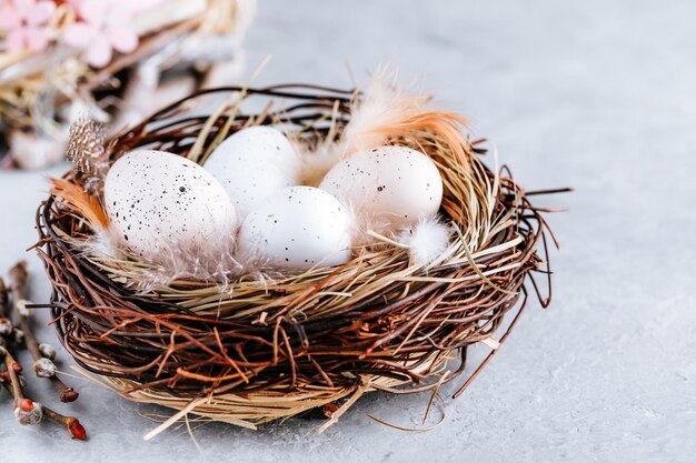 Uova di Pasqua nel nido su sfondo grigio pietra copia spazio Buona Pasqua