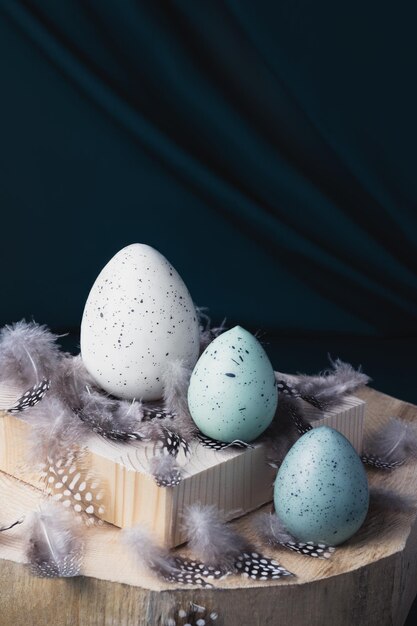 Uova di Pasqua su uno sfondo di legno e rami di prugna in fiore. Concetto di Pasqua.