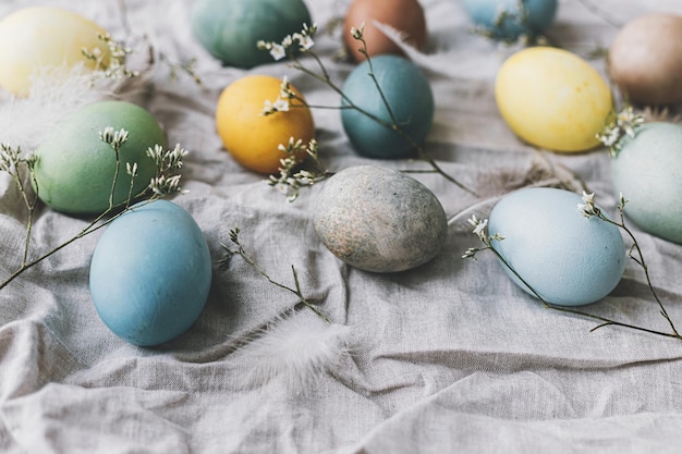 Uova di Pasqua sul tovagliolo di lino rustico con teneri fiori Buona Pasqua Natura morta rustica