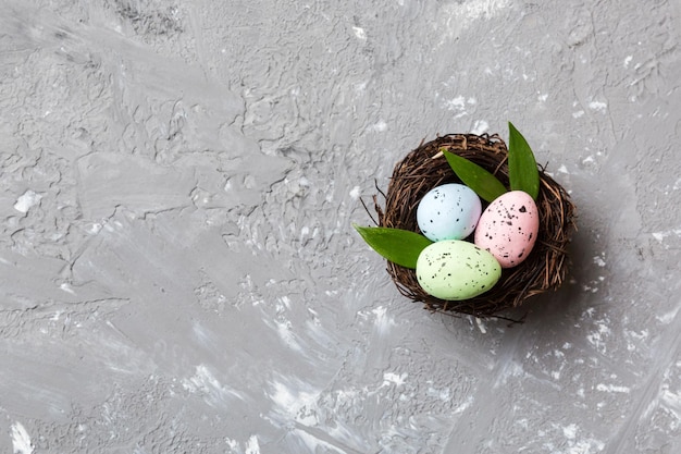 Uova di pasqua variopinte in nido sul fondo della tavola con la vista superiore dello spazio della copia