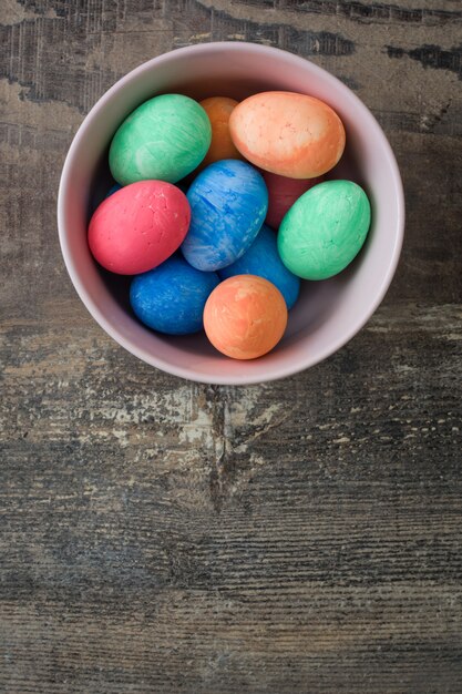 Uova di Pasqua variopinte tradizionali in ciotola su un di legno