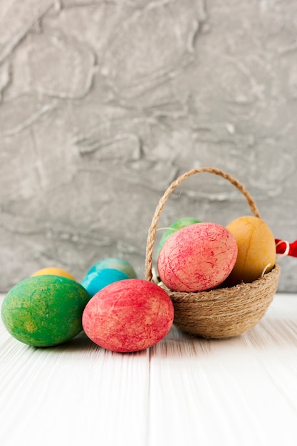 Uova di Pasqua vicino piccolo cestino