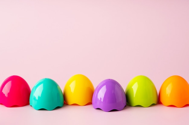 Uova di plastica colorate giocattolo su sfondo rosa. Fondo luminoso di Pasqua del giocattolo. Concetto di Pasqua Montessori. Uova di Pasqua per bambini.