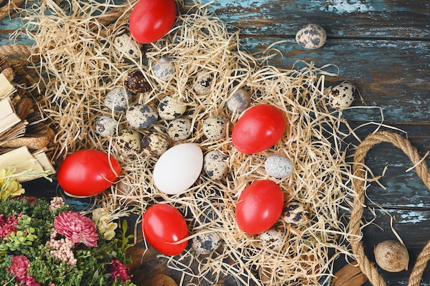 Uova di pollo bianche uova rosse uova di quaglia vicino a fiori secchi Uova per Pasqua