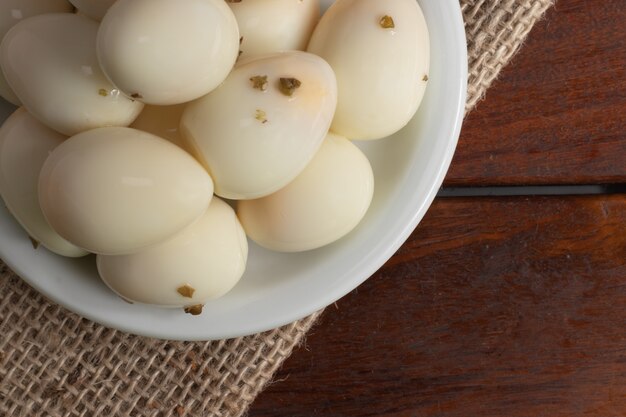 Uova di quaglia marinate sul piatto bianco.