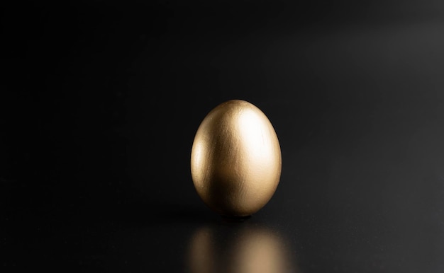 Uova di uccelli d'oro di Pasqua sparate contro uno sfondo scuro