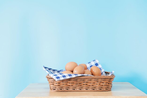 Uova fresche in cestino sulla tavola di legno.