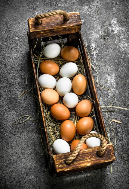 Uova fresche in una vecchia scatola. Su fondo rustico.