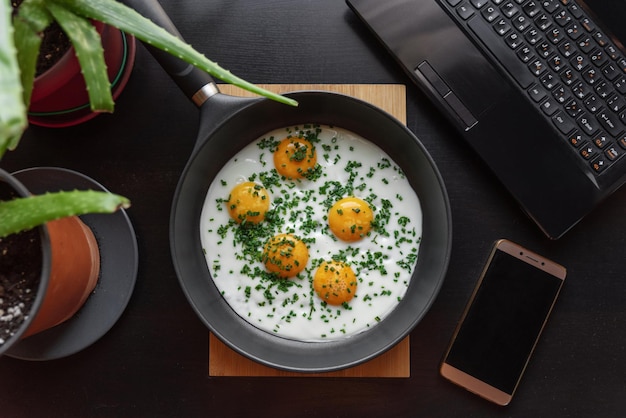 Uova fritte con cipolle verdi in una padella